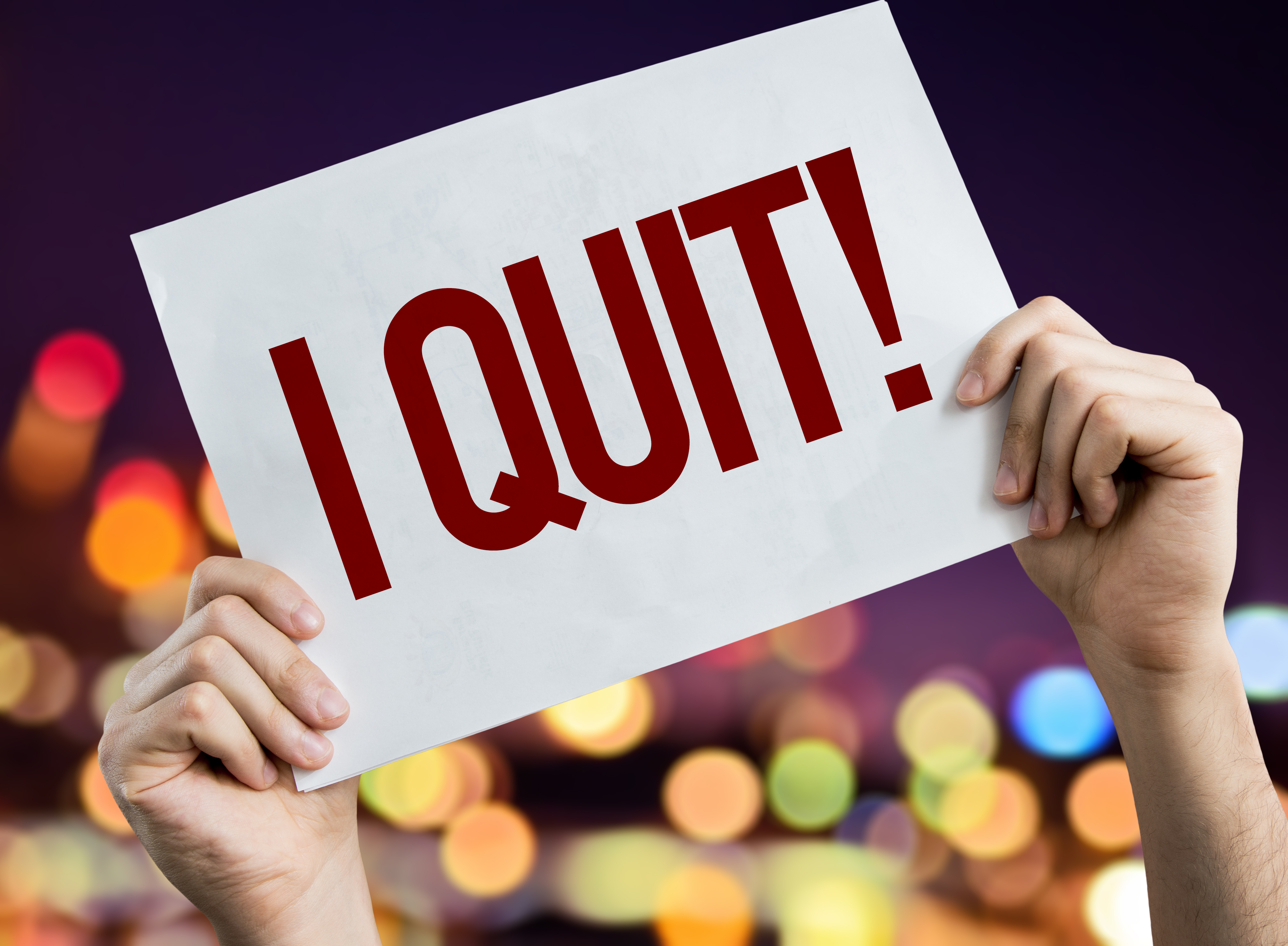 Two hands holding a sign that says I Quit!